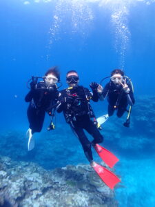 慶良間の海でダイビングを楽しむ親子3人の記念写真